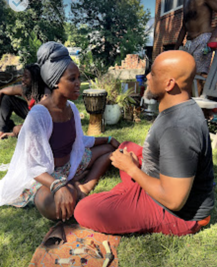 Community dialogue circle on the lawn during sacred ceremony integration